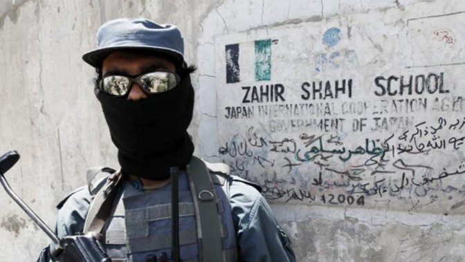 An Afghan policeman stands guard at the entrance of a local school sponsored by Japan’s International Cooperation Agency in Kandahar City May 11, 2010. © 2010 Nikola Solic / Reuters